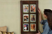 woman hangs picture frame on wall