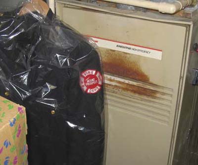 fire uniform hung in front of a furnace causing a fire hazard