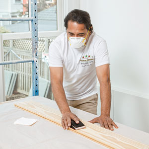 painter Mauro Henrique preps pine for whitewashing in the TOH TV Cambridge house
