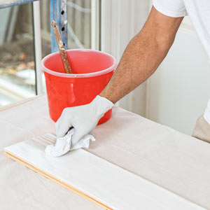 painter Mauro Henrique wipes away unabsorbed whitewashing in the TOH TV Cambridge house