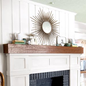 fireplace redo after with white wood trim, rustic mantelshelf and black-painted firebox