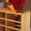 using a handsaw to trim the ends off of a dresser