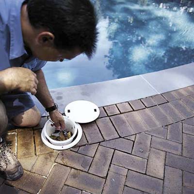 GETTING RID OF DEBRIS BY EMPTYING THE SKIMMER BASKET