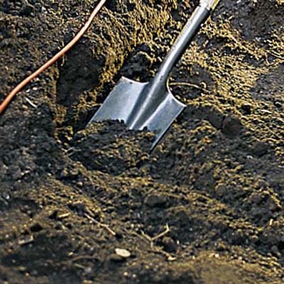 Forming the trench with a shovel.