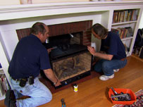 richard and a fireplace expert help a homeowner install a new gas fireplace insert