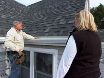 tom and a homeowner check the newly installed house gutters