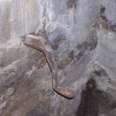 metal object visually similar to an antique crank sticking out of exterior wall