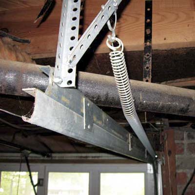 garage door spring stretched around a pipe and other obstructions