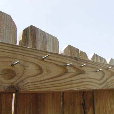 oversized nail points sticking about an inch out of the back of a wooden fence