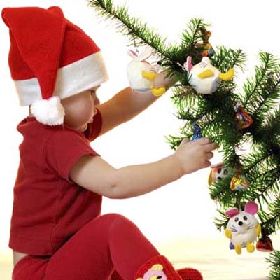 child pulling down a fully decorated christmas tree
