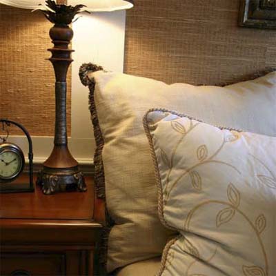 close-up image of pillows nightstand clock and lamp in a guest bedroom