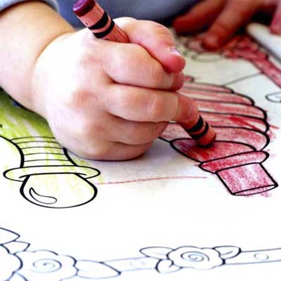 child's hand coloring with crayon