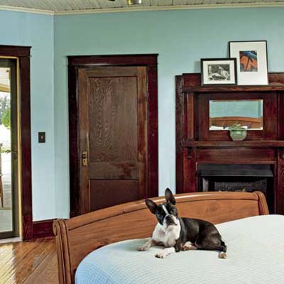 boston bulldog lying on bed in bungalow's master bedroom after renovation with vent-free gas fireplace