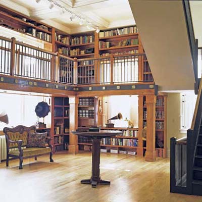 two-story library with pedestal table and tall ceiling in former post office