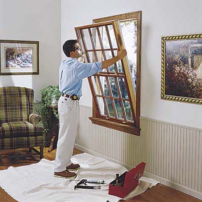 person installing a window into an opening in an outside wall