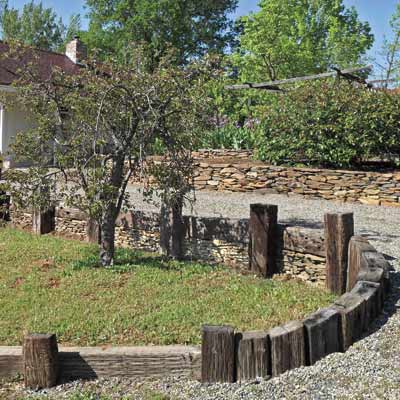 a retaining wall that is also edging for a gravel driveway