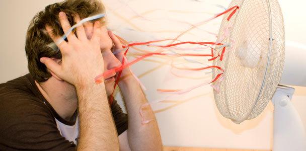man cooling down in front of oscillating fan