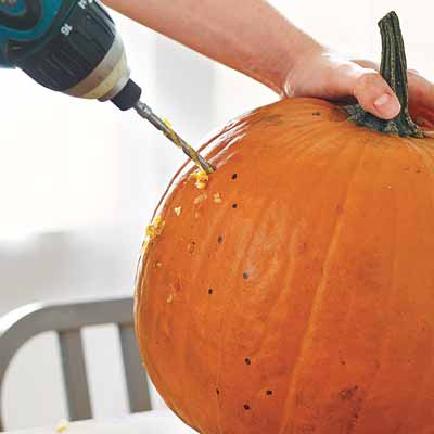 drilling designs into pumpkins and lighting them with strings of christmas lights