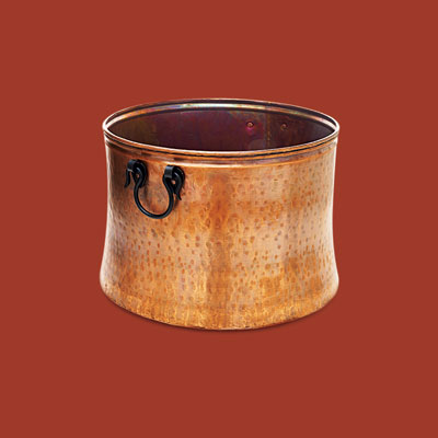 a hand-hammered copper bucket for storing firewood
