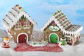 a pair of gingerbread houses with Santa and Frosty against a blue sky background