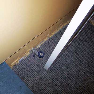 a water valve situated right behind a living room door