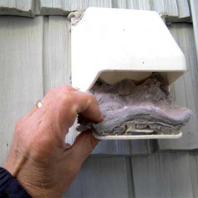 a dryer vent showing the screen being removed to reveal a massive coating of lint