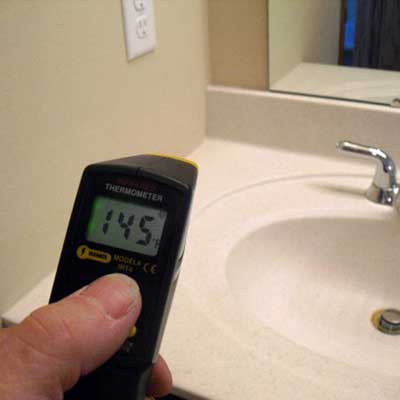 a point-and-shoot thermometer in the bathroom revealing the temperature to be 145 degrees