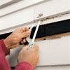 man using hacksaw blad to cut nails in clapboard siding