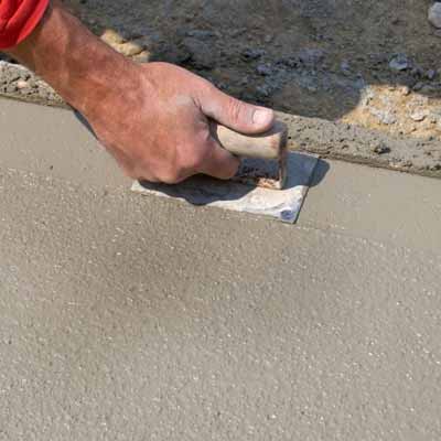 man laying concrete pathway