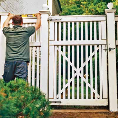 man checking fence and gate level