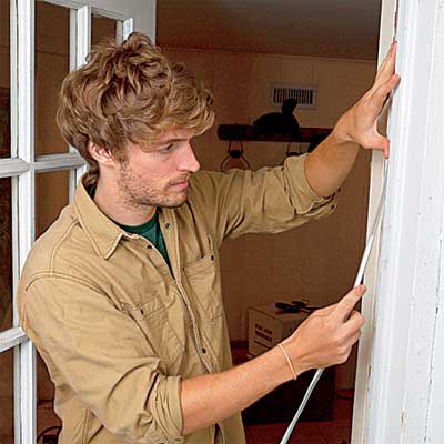 person installing weather stripping to a door