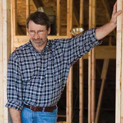 carpenter leaning against wood frame