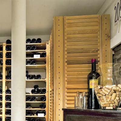 louvered panels disguising the air conditioner in this remodeled basement wine celler