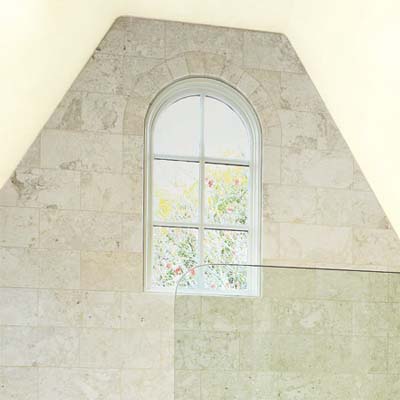 hand cut and marble tiles lining the bath in this attic remodel