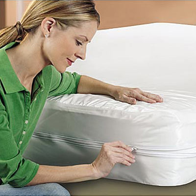 woman zipping up allergen free mattress covering