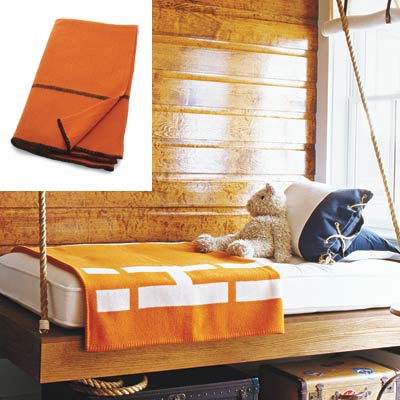 cabin style bedroom with orange wool blanket