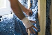 man installing recycled denim insulation batts