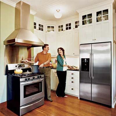 homeowners smiling in the newly remodeled kitchen of this victorian and craftsman style cottage