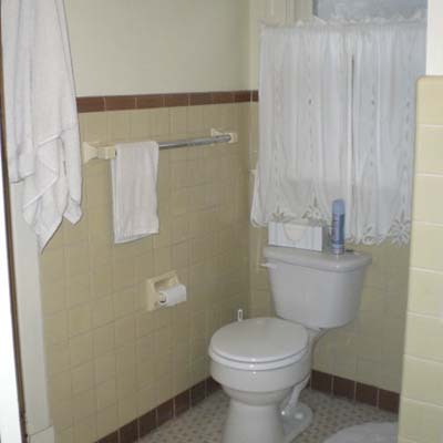 outdated bathroom with off white tile and white toilet