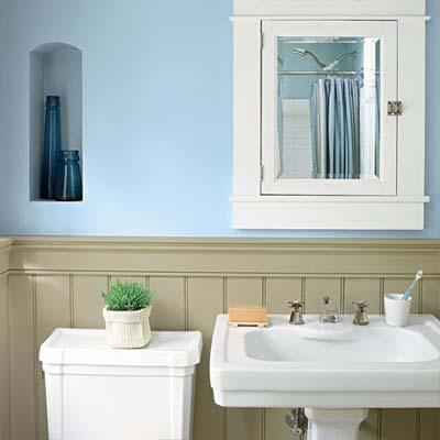 bathroom with blue walls and white cabinet, sink and toilet