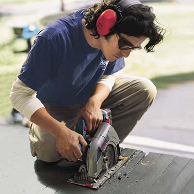 man using a circular saw to cut deck boards