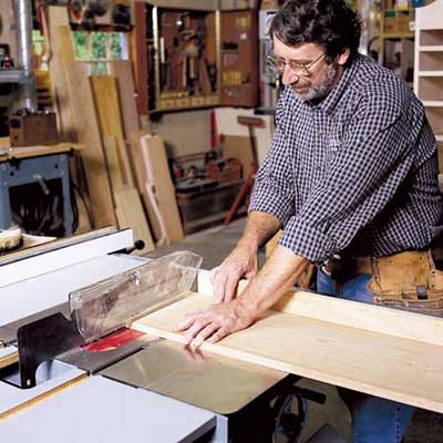 man using table saw in workshop