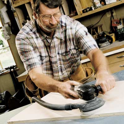 man using random orbit sander