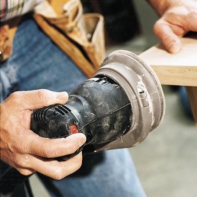 man sanding edge with random orbit sander