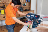 man sawing board with miter saw