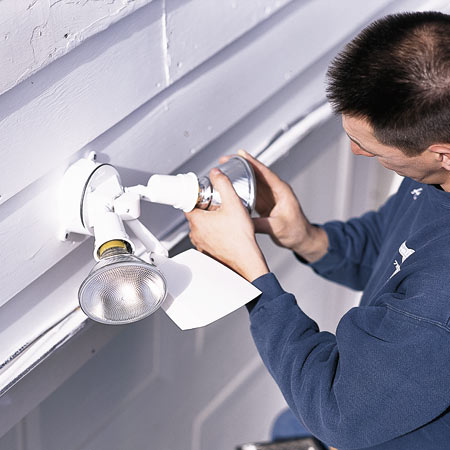 man installing floodlight