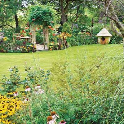 birdhouse above bed of coneflowers and black eyed susans