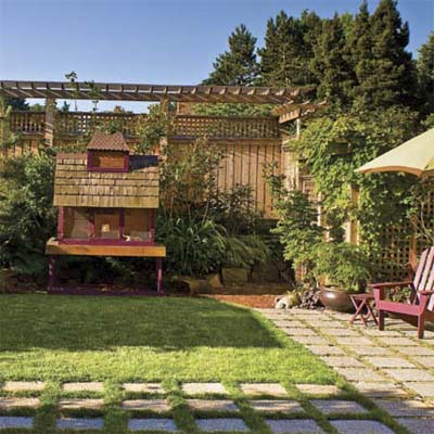 sustainable garden: outdoor aviary Carlson built from salvaged shipping pallets, roof shingles, and sparrow netting