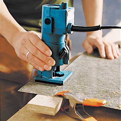 person cutting laminate on a work suraface