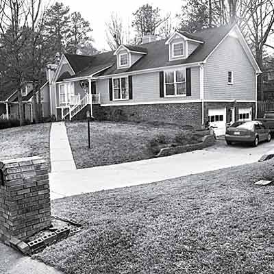 neo-colonial house with lackluster lawn and little curb appeal

